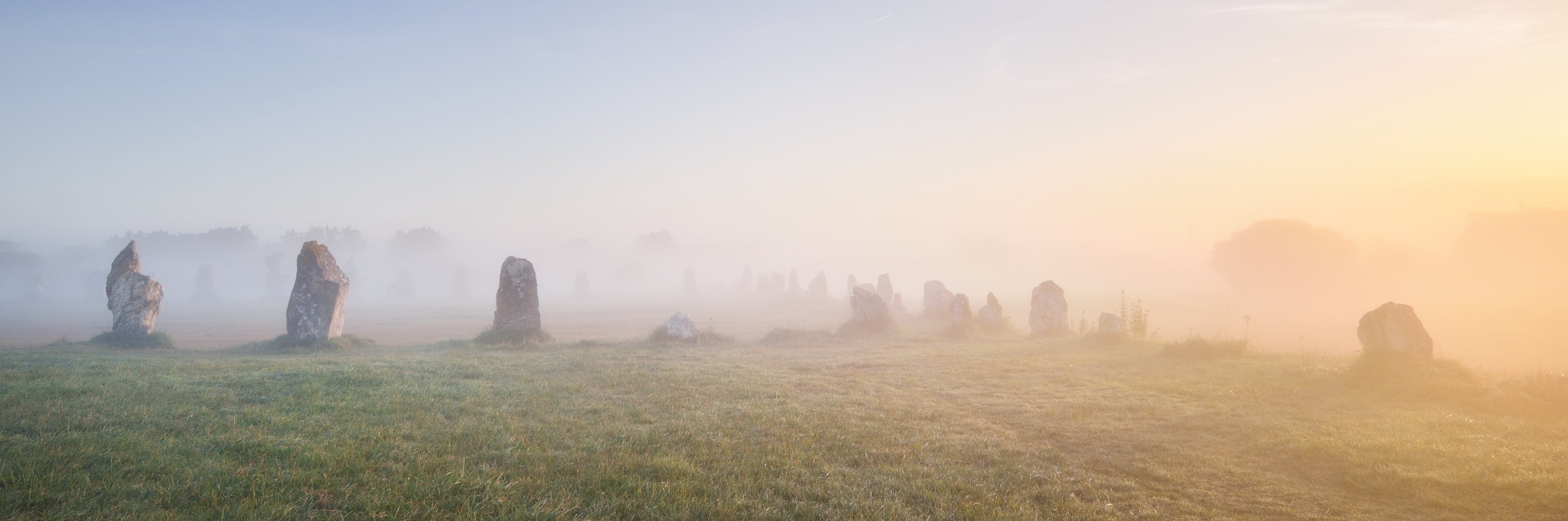 Alignement de menhirs dans la brume, évoquant l’esprit et les paysages de Bretagne – image d’accueil Bevet Breizh, style breton authentique.